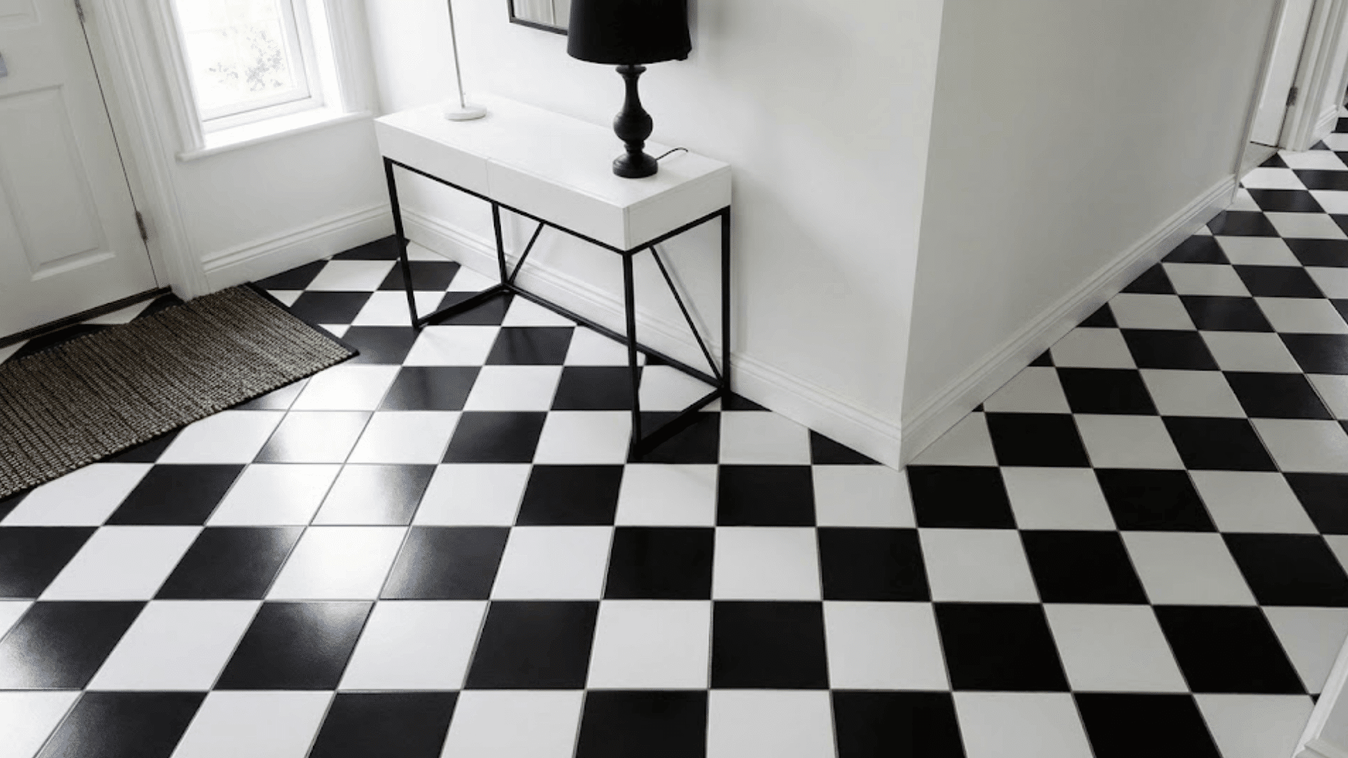 black and white checkerboard tile flooring in 12 inch squares with white console and glossy finish