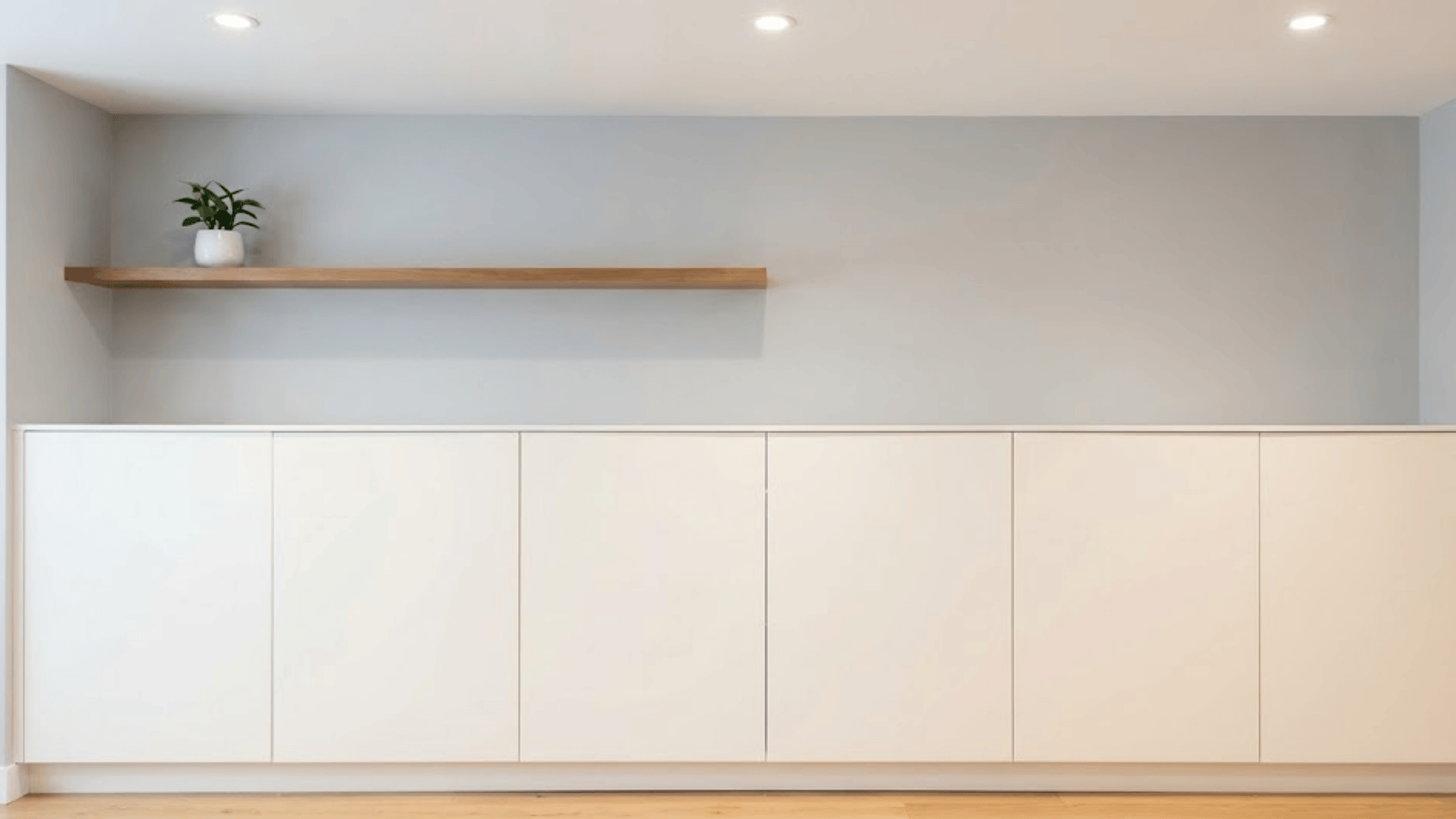 seamless white closed cabinetry with flush handleless doors creating minimal uncluttered entryway wall