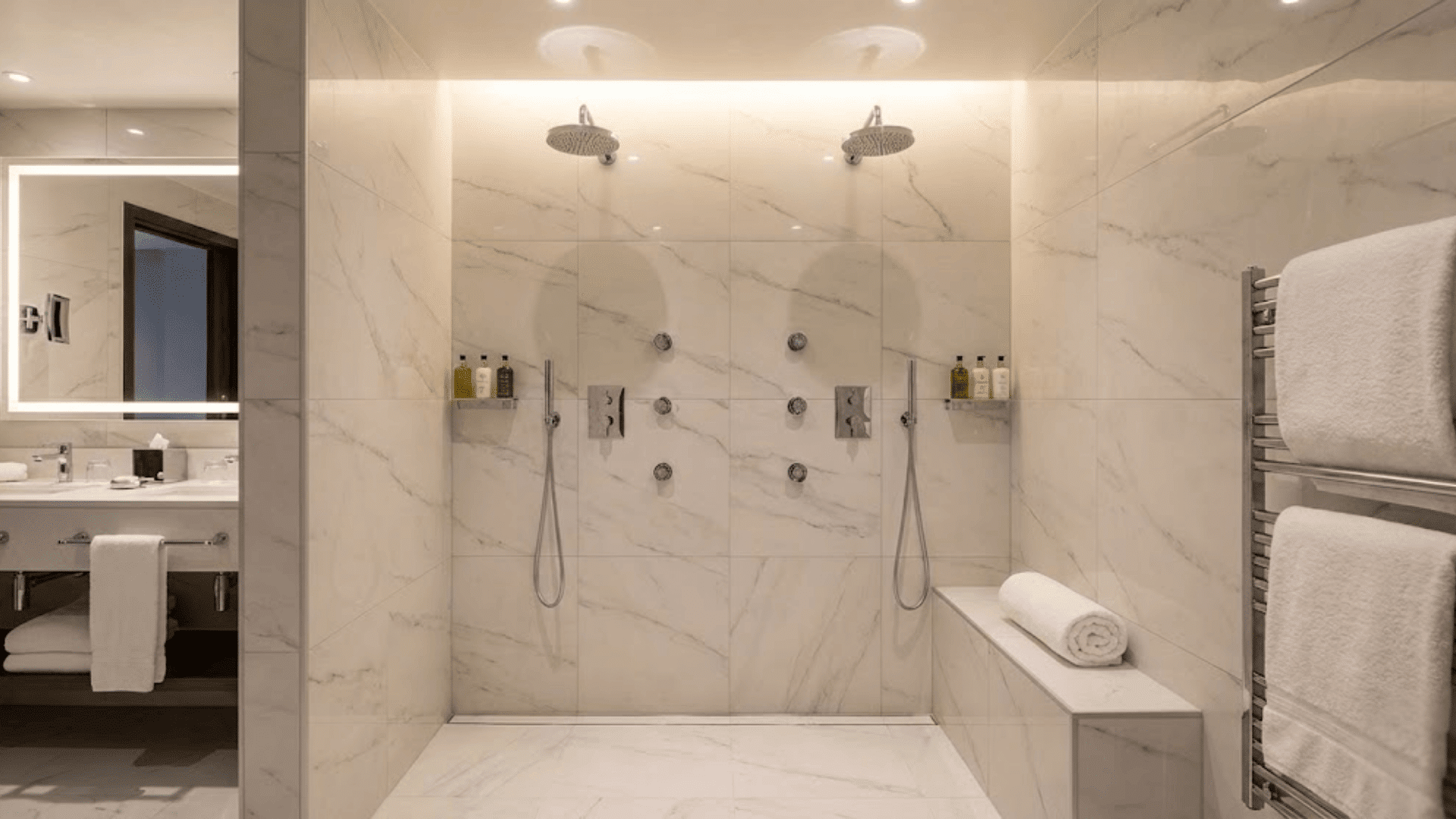 luxury hotel-style doorless shower with dual rainfall showerheads and pristine white marble tiles