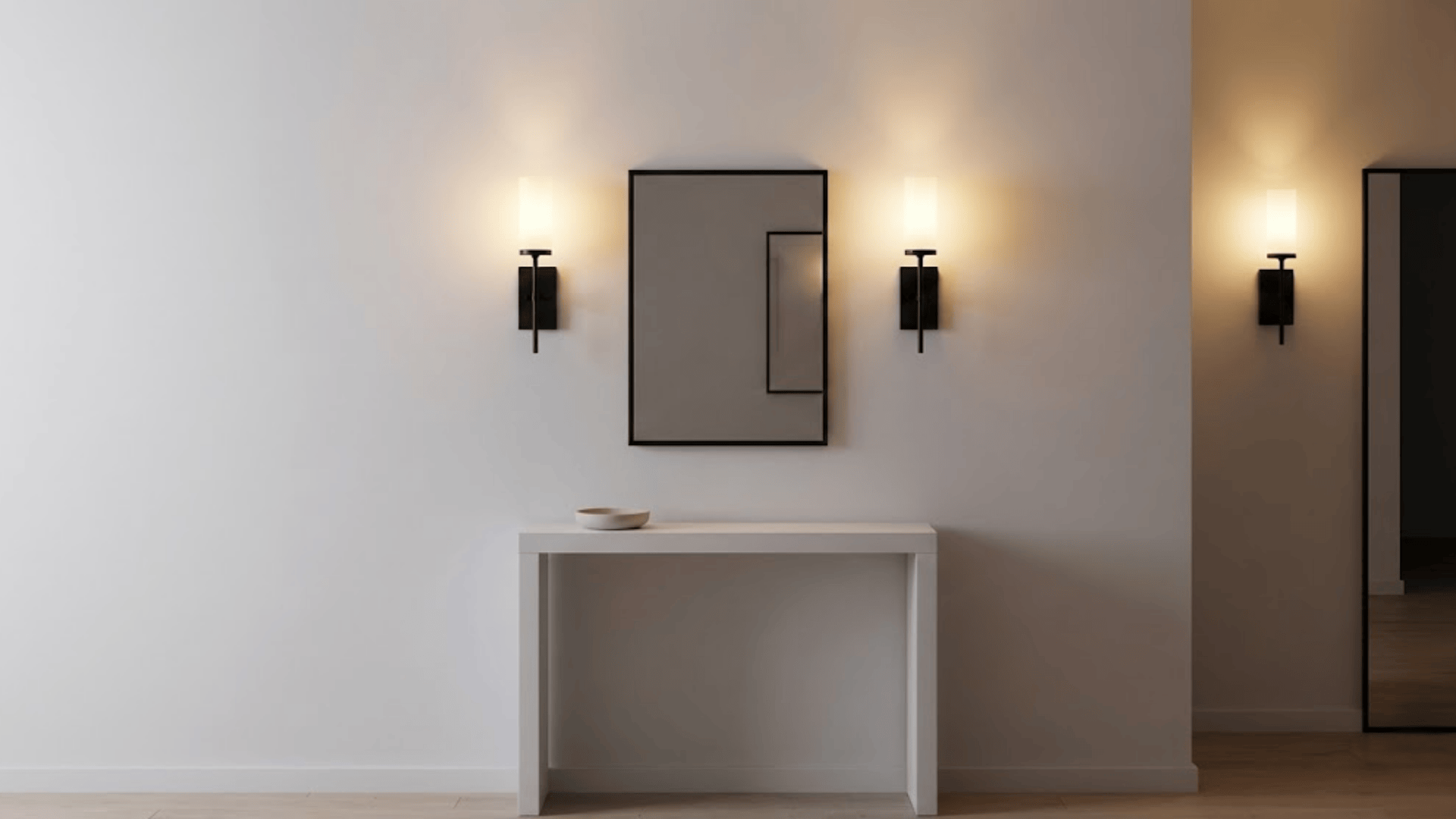 modern black wall sconces flanking rectangular mirror with frosted glass shades creating symmetrical lighting