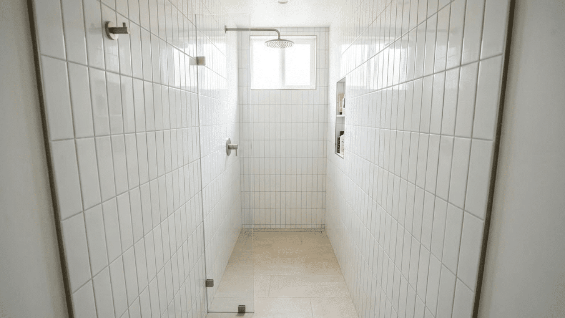 narrow galley-style doorless shower with vertical white tiles maximizing height in small space