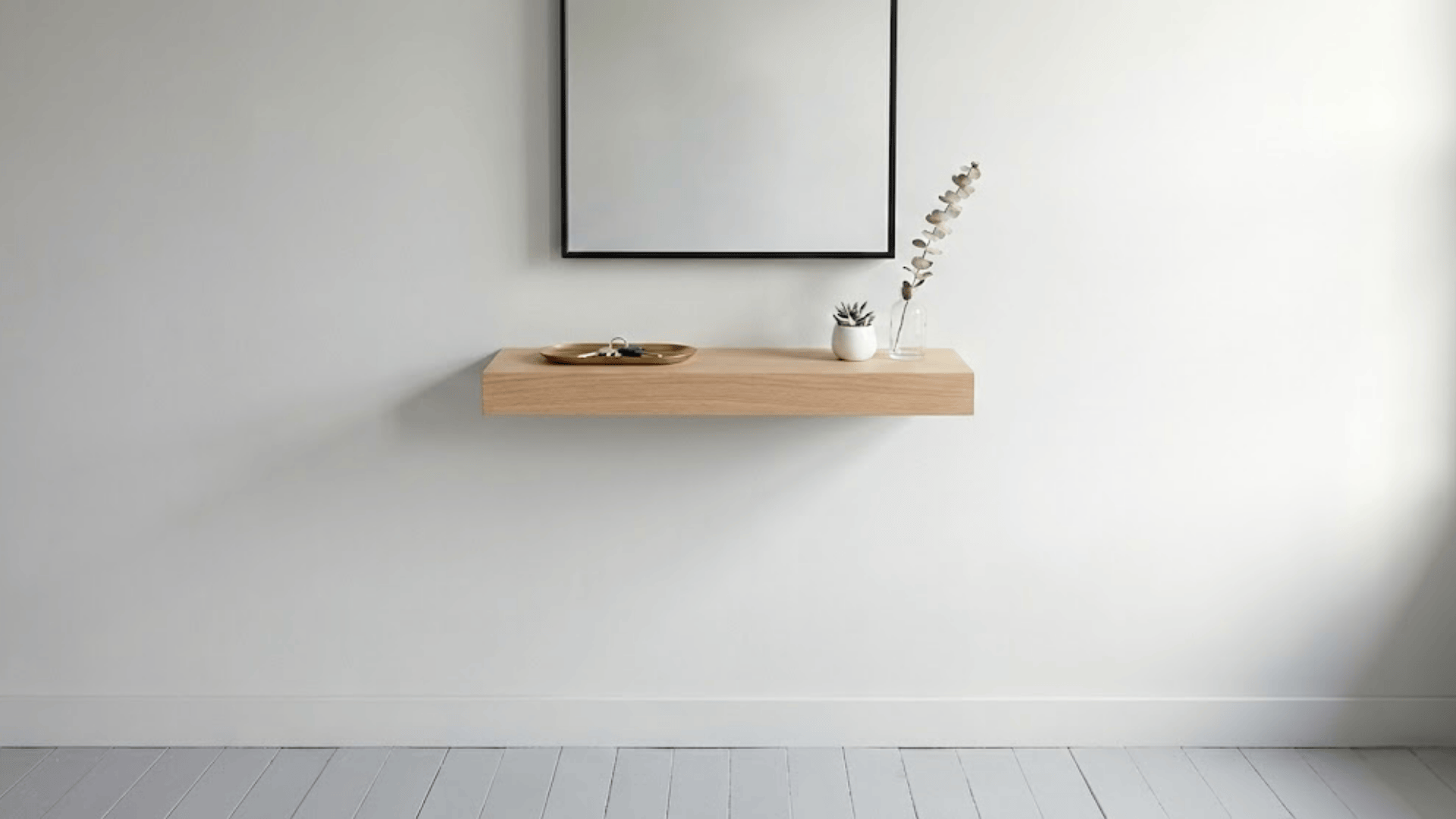 narrow floating white oak shelf with round mirror above holding keys succulent and brass tray