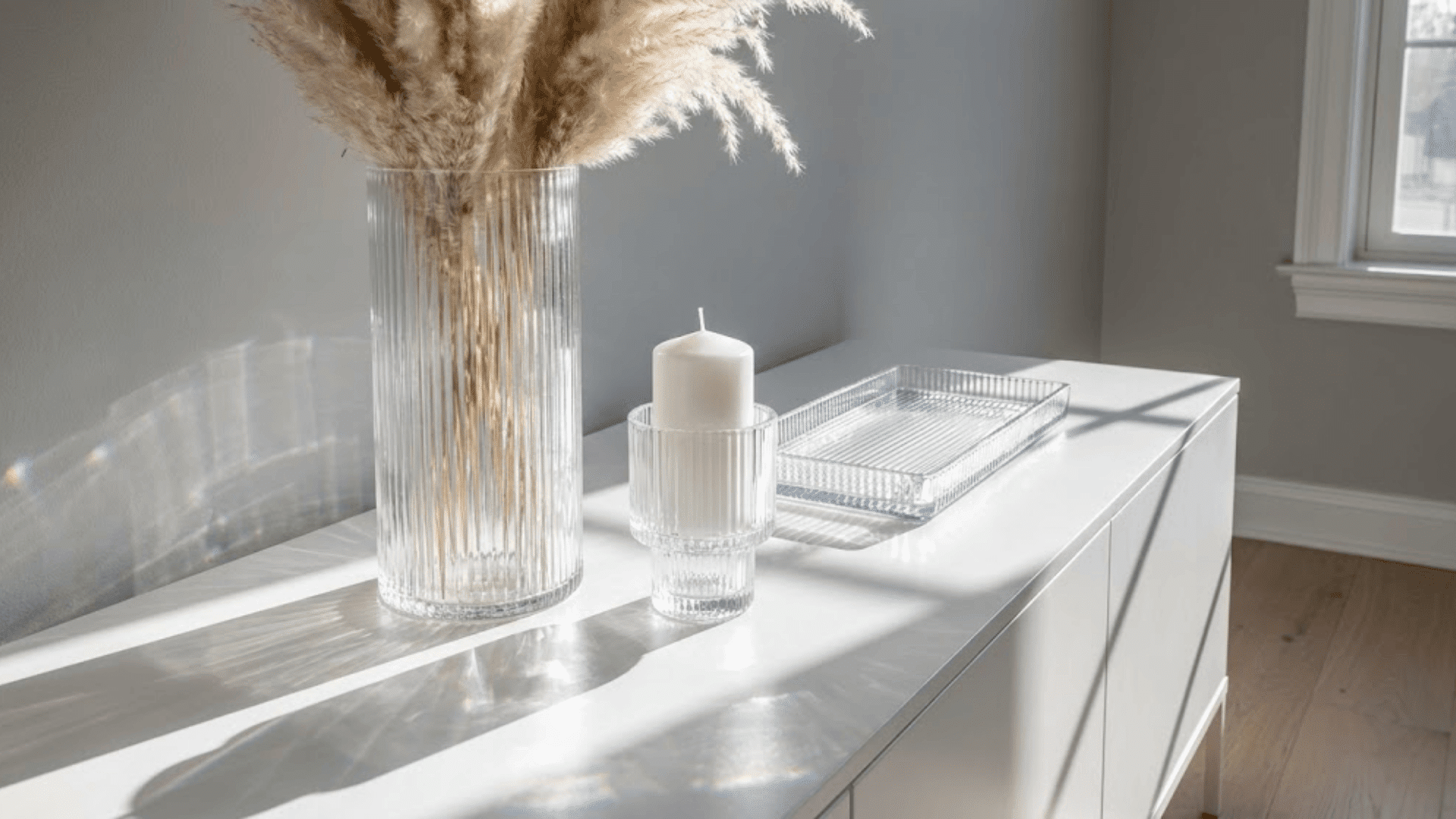 ribbed glass vase candle holder and tray on white console refracting light with vertical fluted texture