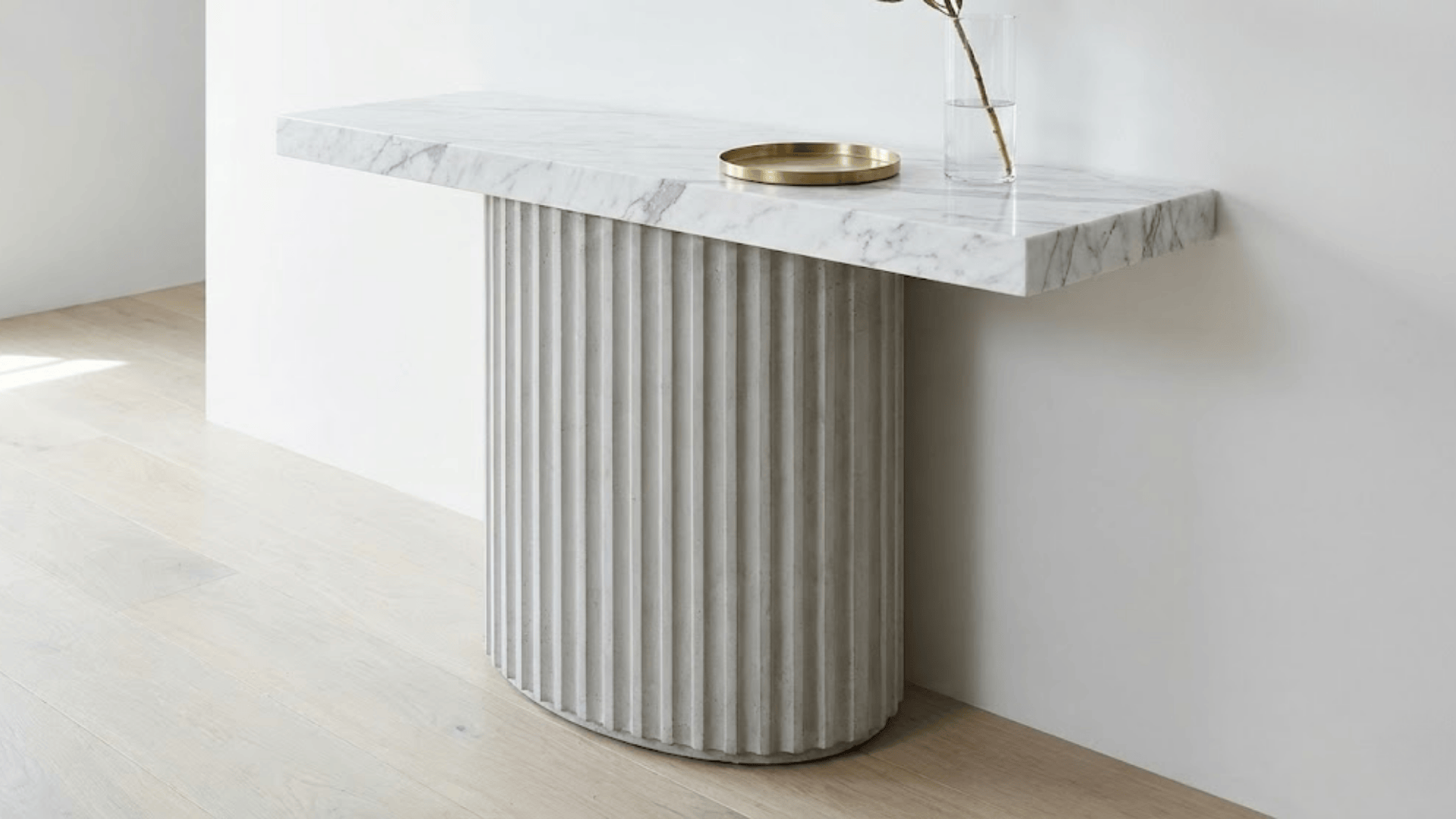 sculptural console table with white marble top and fluted concrete base in modern minimalist entryway
