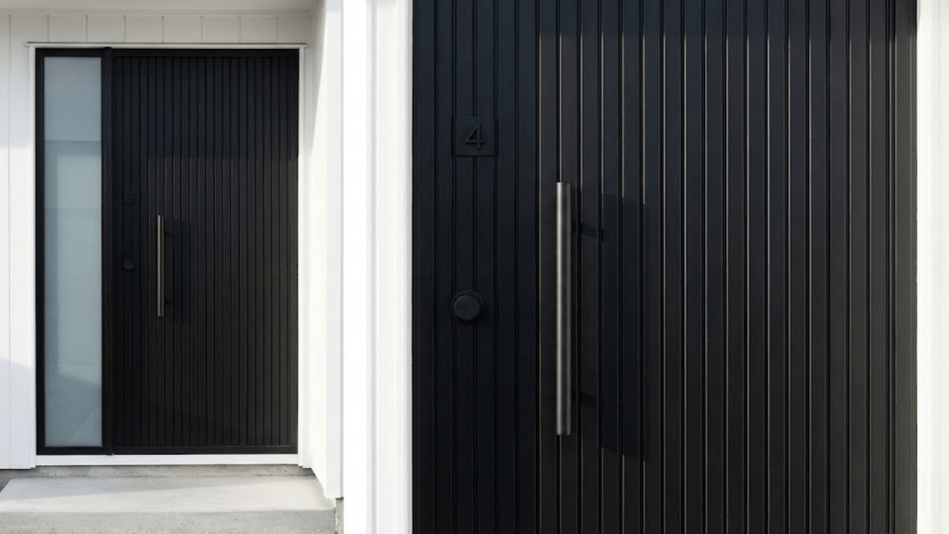 modern matte black front door with vertical grooves oversized handle and house number on white frame