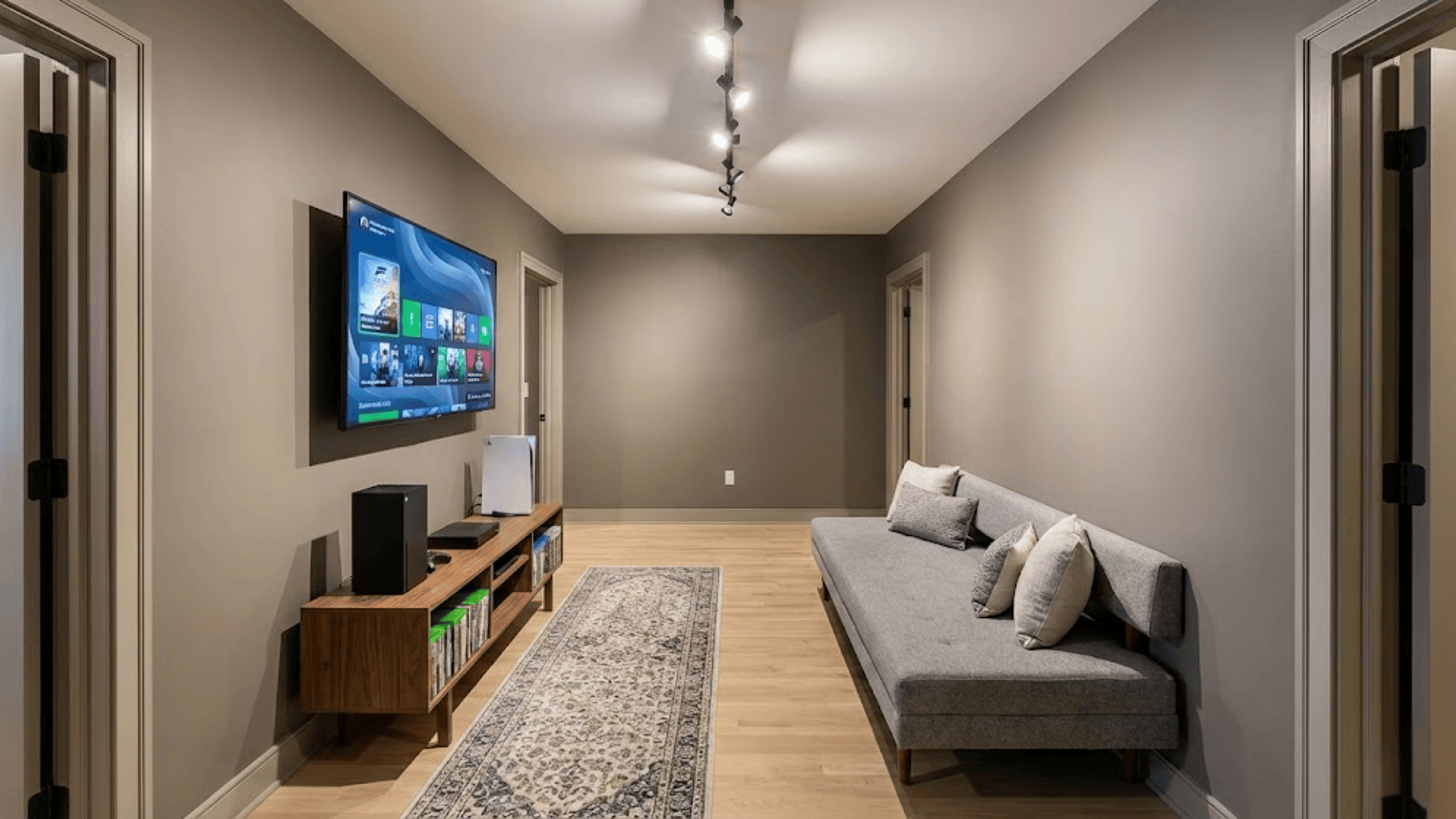 narrow room with tv console setup on one wall and slim bench seating opposite maintaining clear walkway