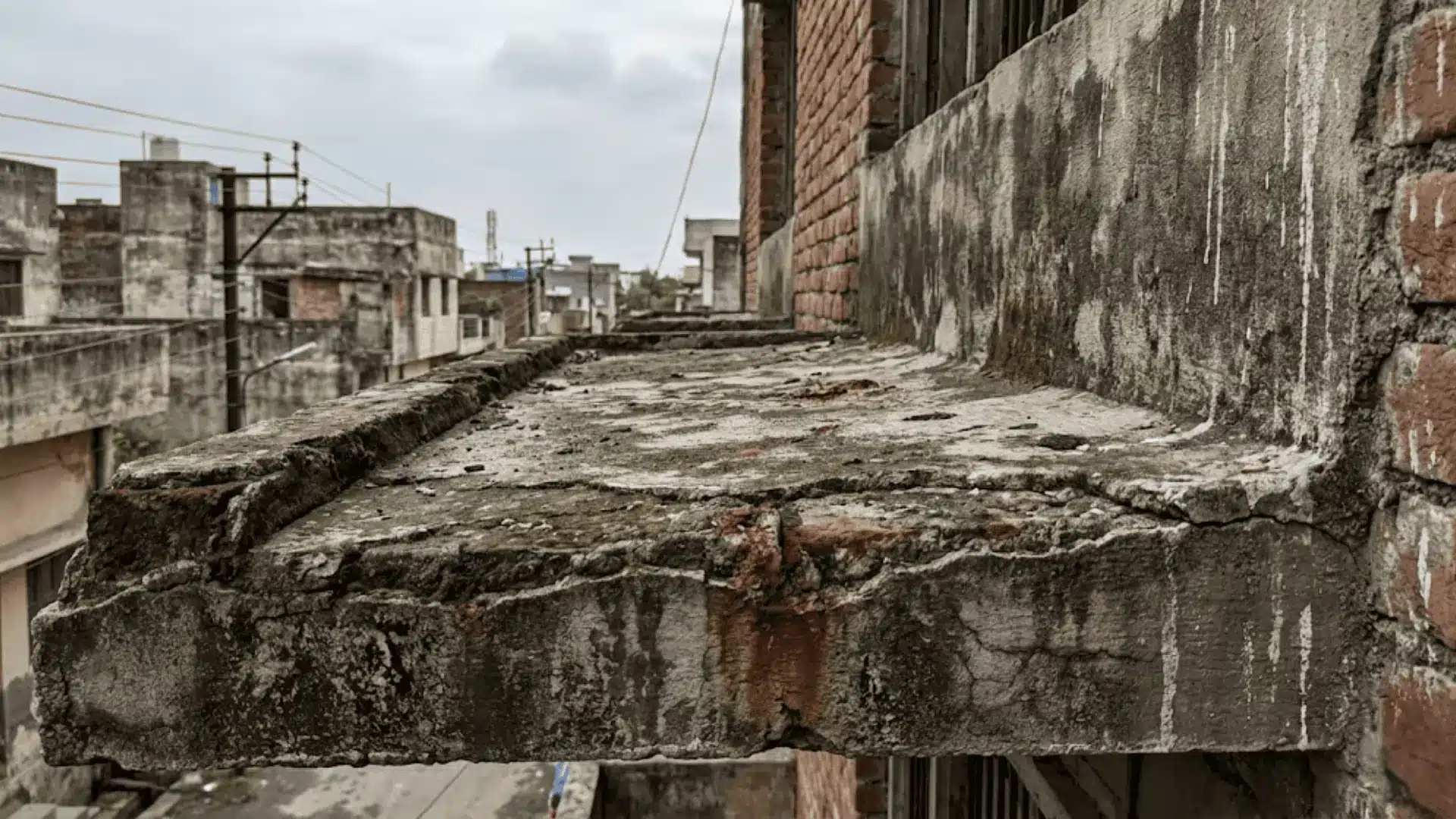weathered concrete rooftop ledge on an older urban building with natural surface staining and soft overcast daylight