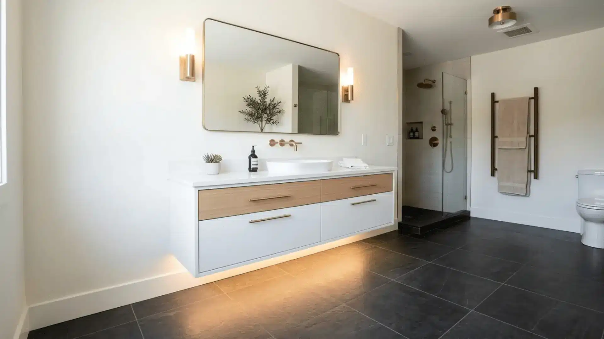 floating white vanity with warm LED underlighting, oak drawer fronts, and charcoal tile floor