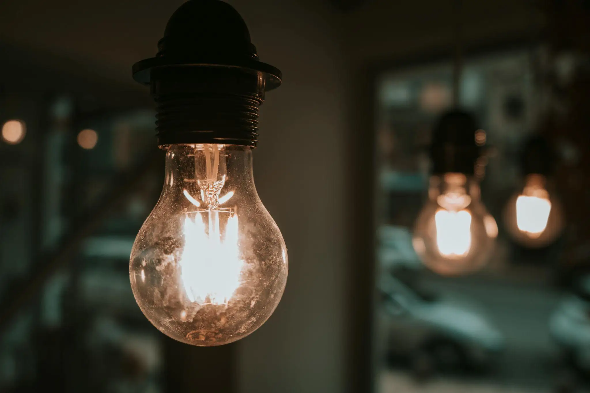 Close-up of glowing light bulbs hanging indoors with blurred background and warm lighting