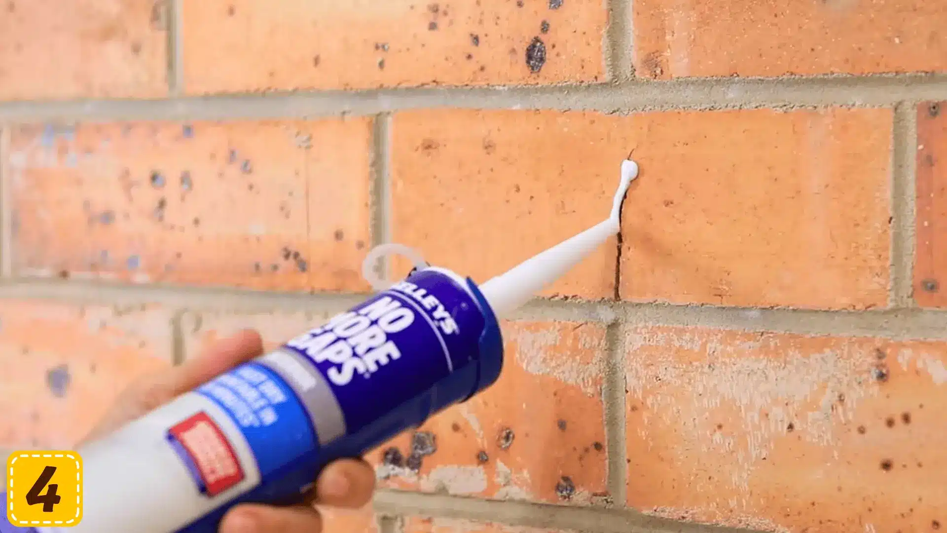 applying flexible gap filler to a crack in a brick wall before painting