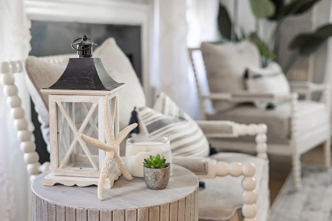 Decorative lantern and starfish on round wooden table in cozy living room