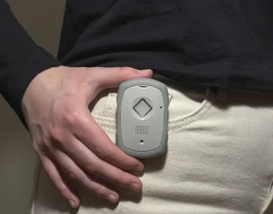 Person holding a gray safety device clipped to beige pants indoors