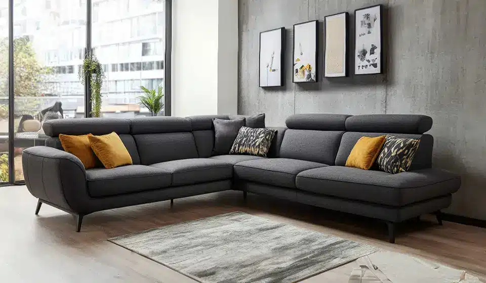 Dark gray sectional sofa with yellow and patterned pillows in modern living room setting