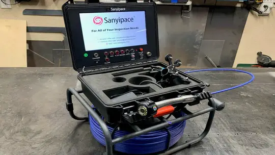 Inspection camera system with coiled blue cable on workshop table