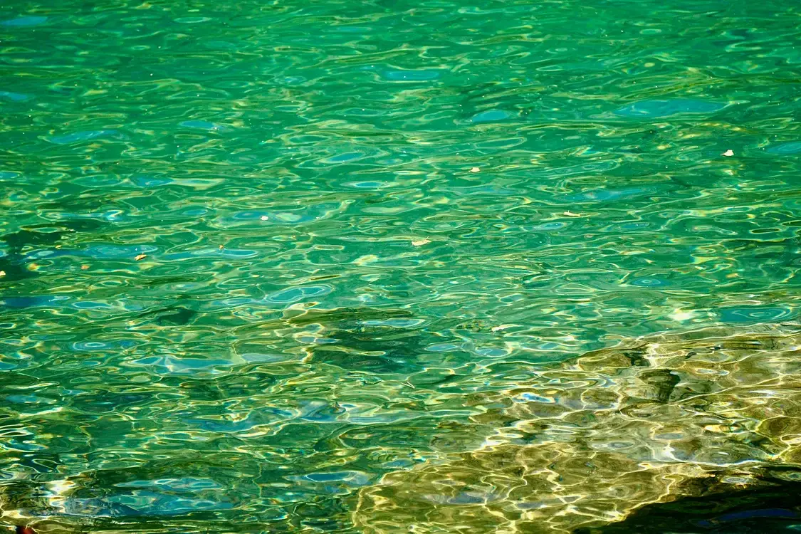 Rippling turquoise water with sunlight reflections in an outdoor setting