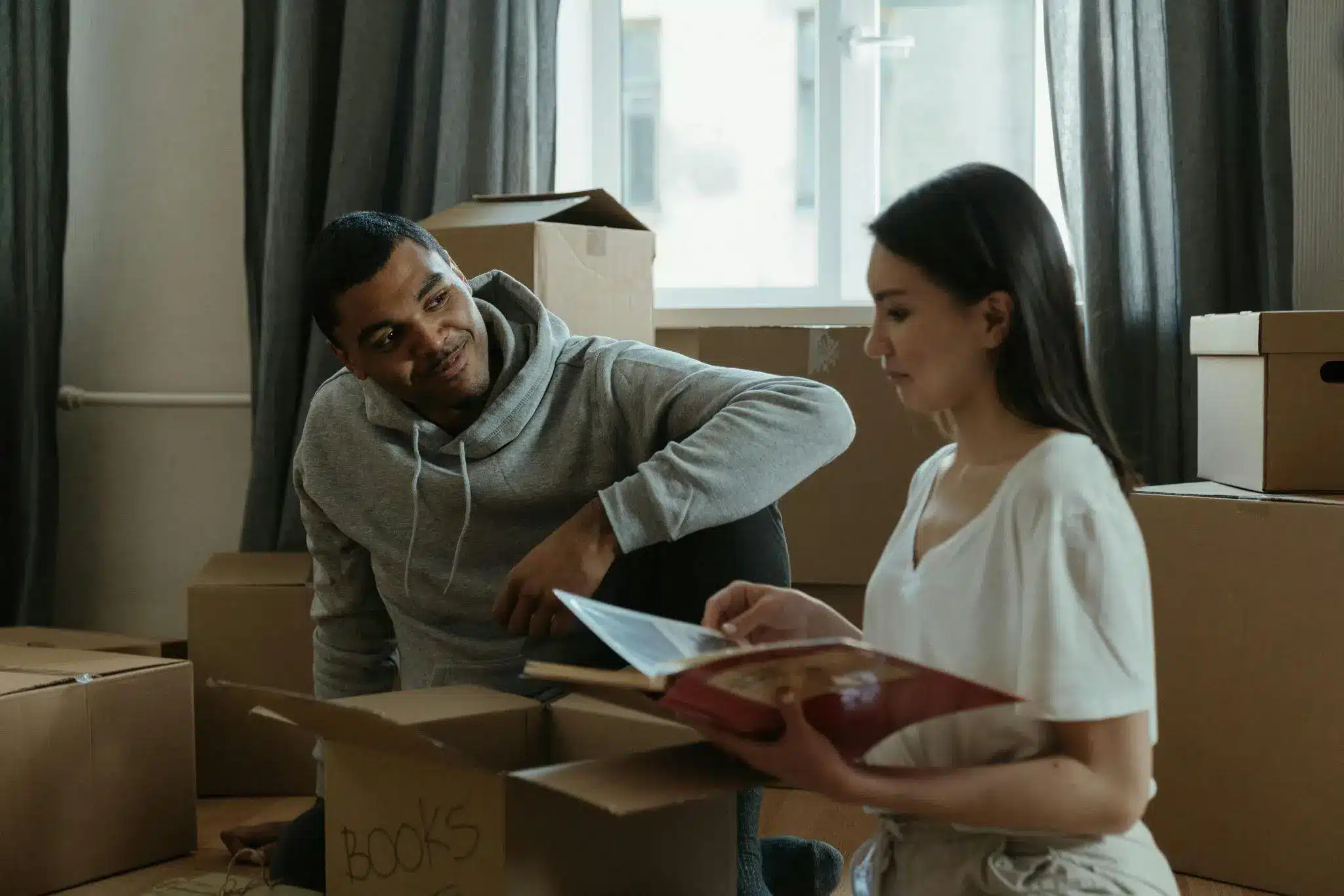 Couple unpacking boxes and reading book in a softly lit room