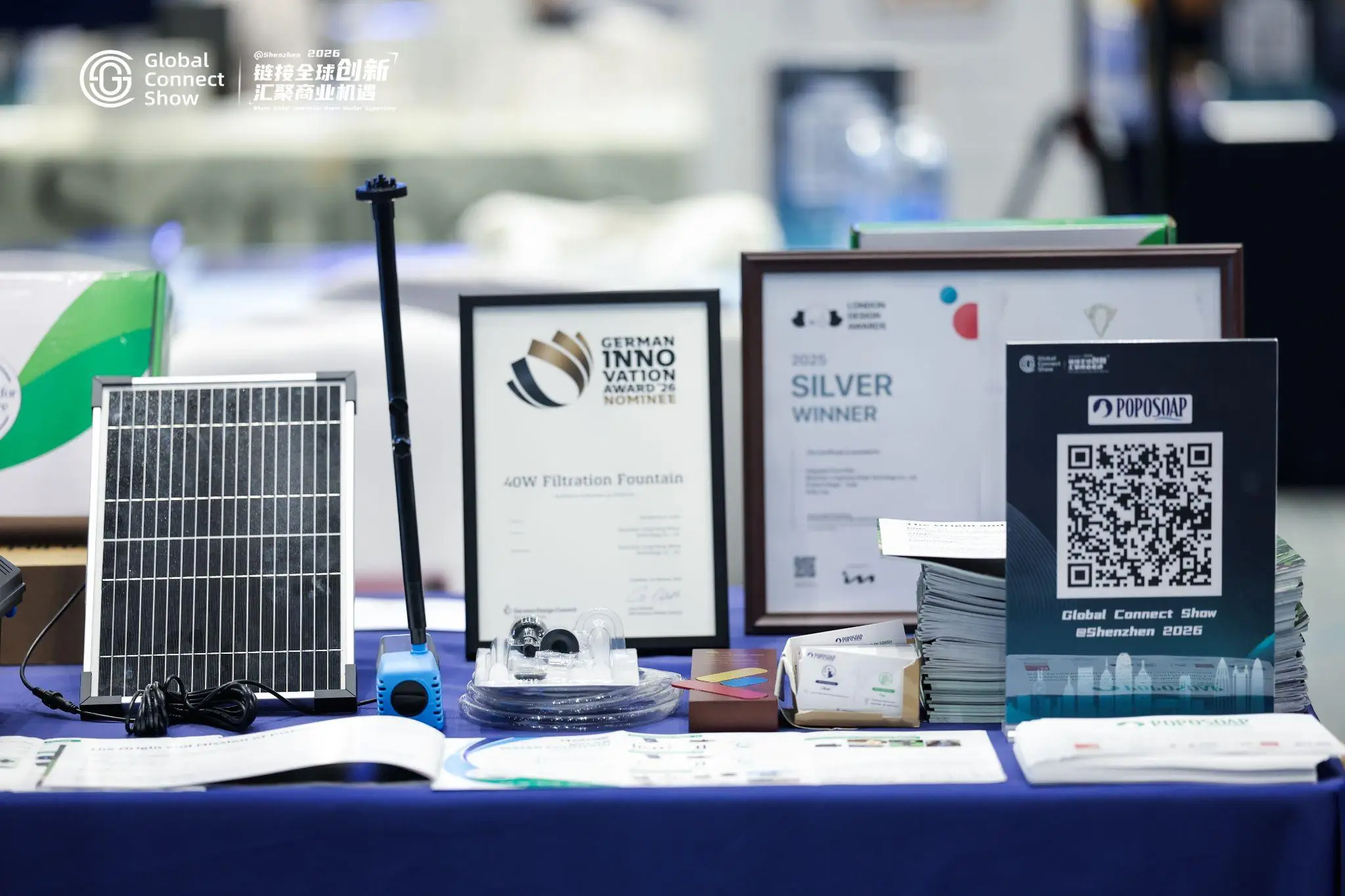 Solar panel and awards displayed on a table at an event with blue tablecloth