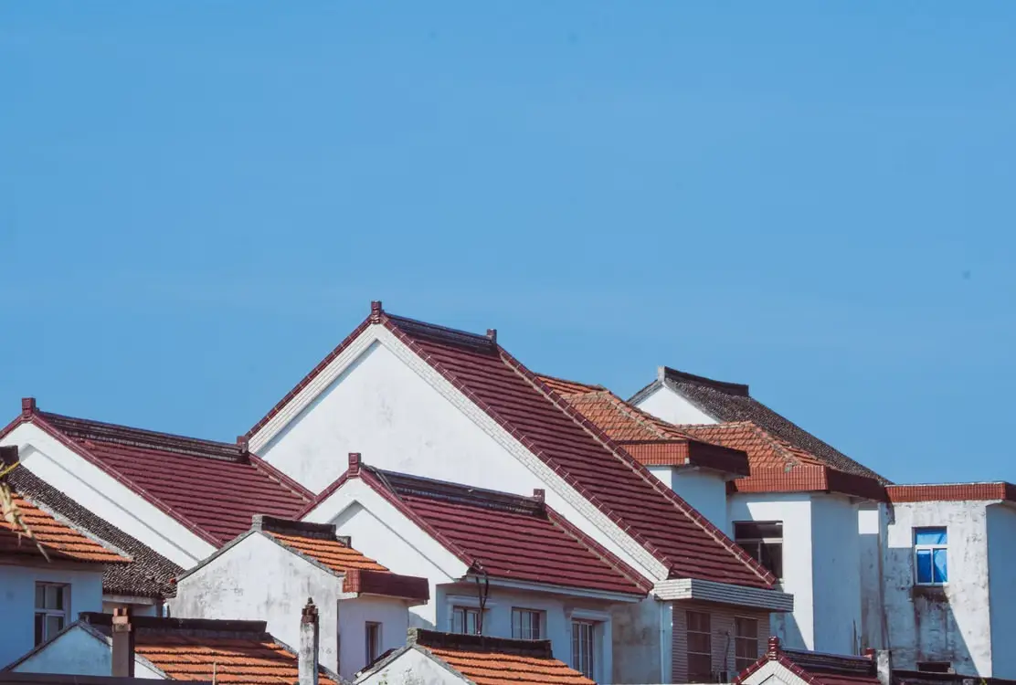 Cluster of houses with red-tiled roofs under clear blue sky