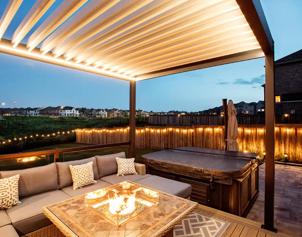 Outdoor patio with cozy seating, fire pit, and string lights under pergola at dusk