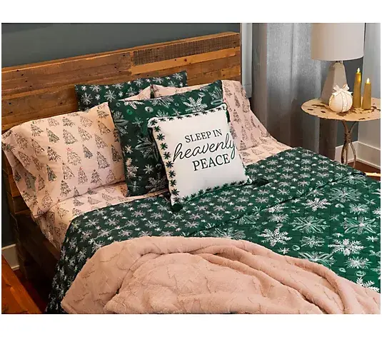 Cozy bed with festive bedding and decorative pillows in rustic bedroom with wooden headboard
