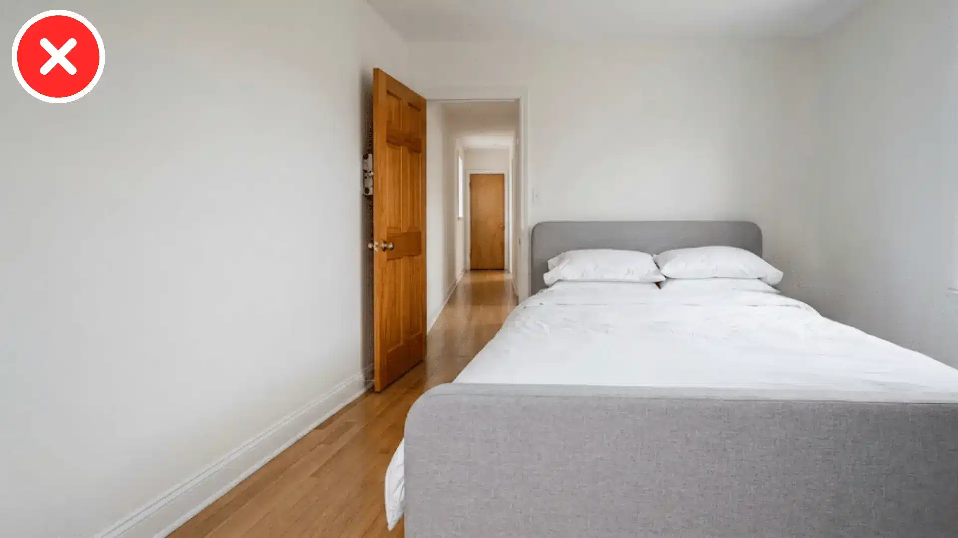 bed footboard wall and open door all visible in a straight line down the room