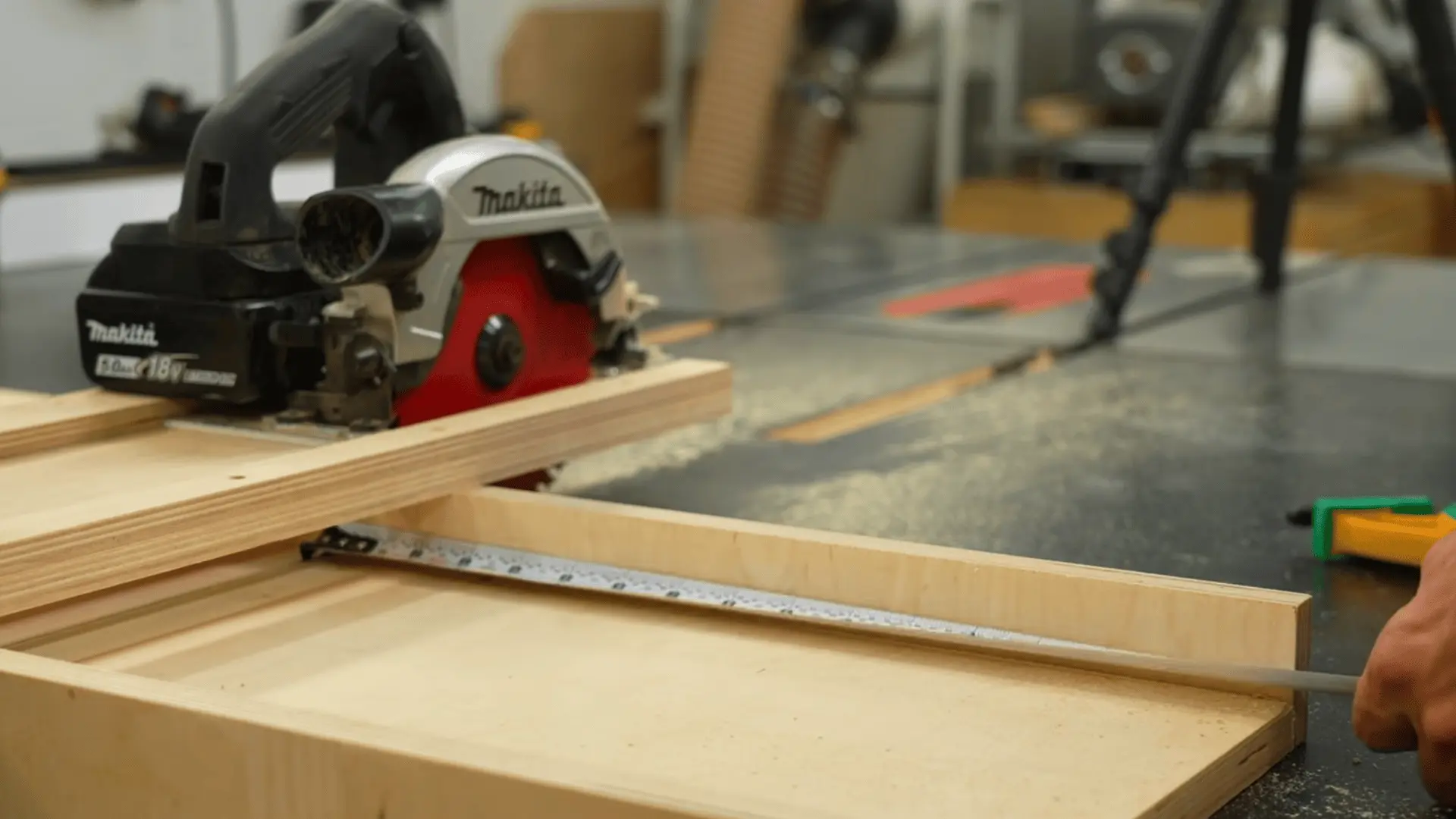 circular saw resting on a plywood strip beside a tape measure used to size drawer slide parts