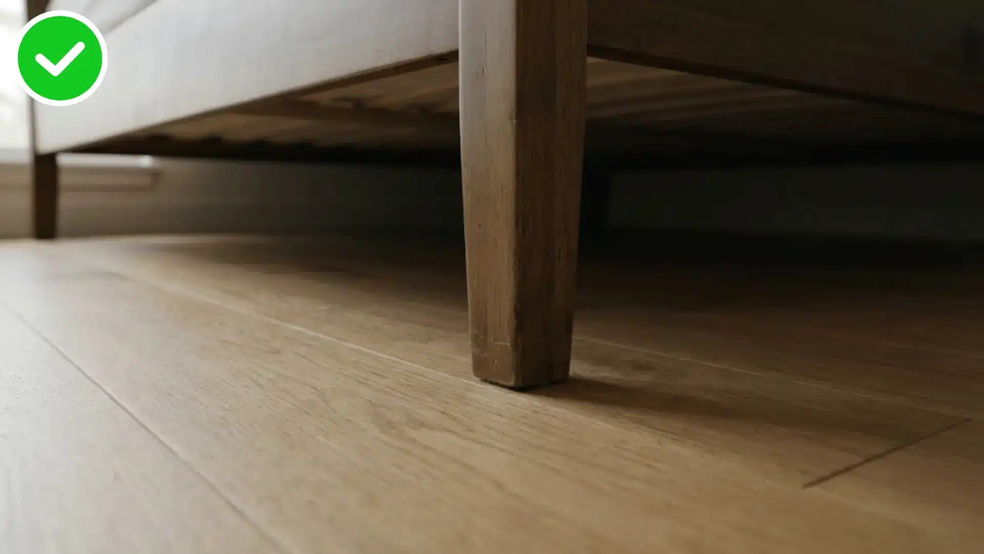 close up under a bed frame leg showing a clean empty floor surface