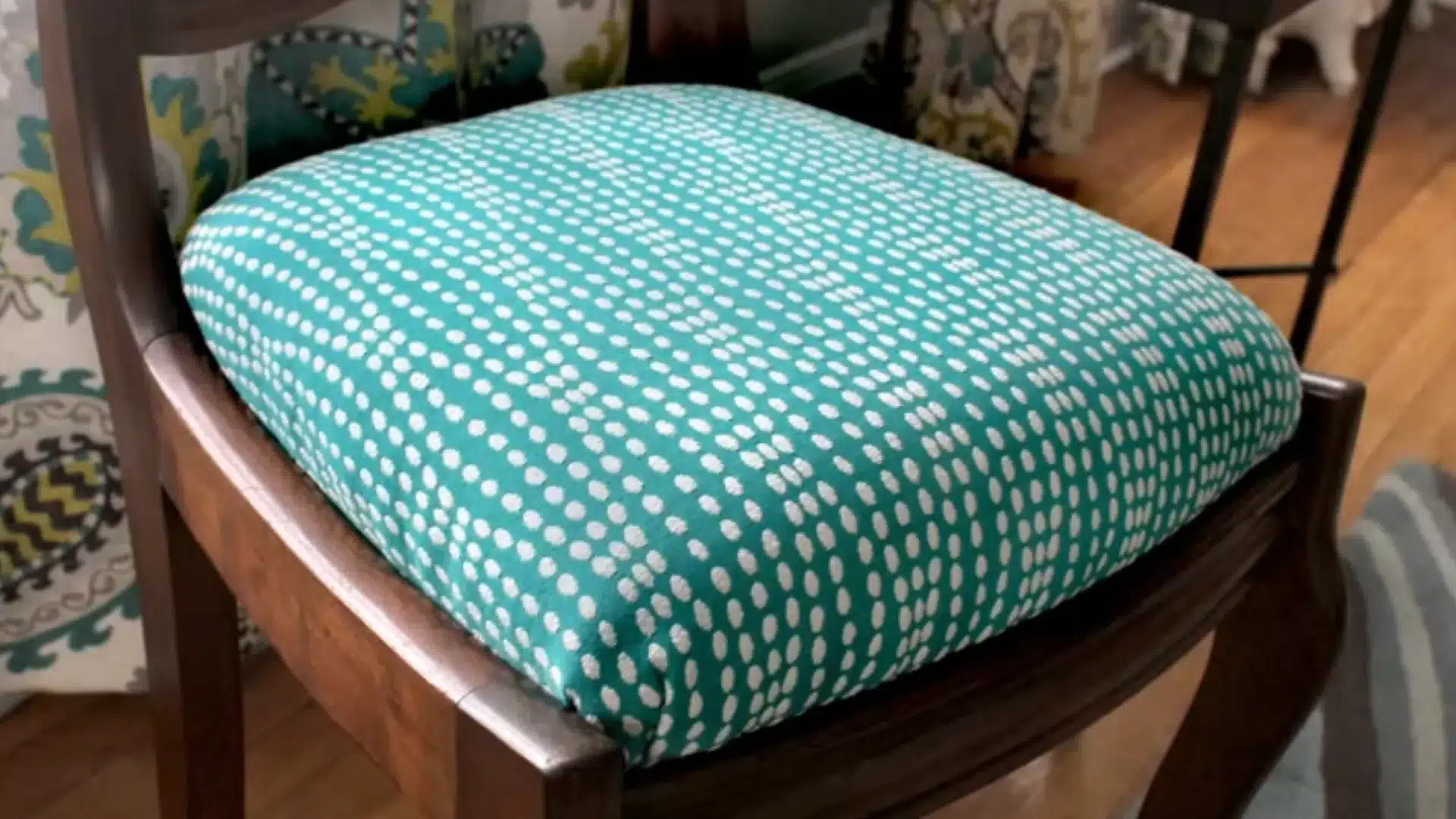 finished wooden dining chair with a newly reupholstered teal patterned seat cushion in place