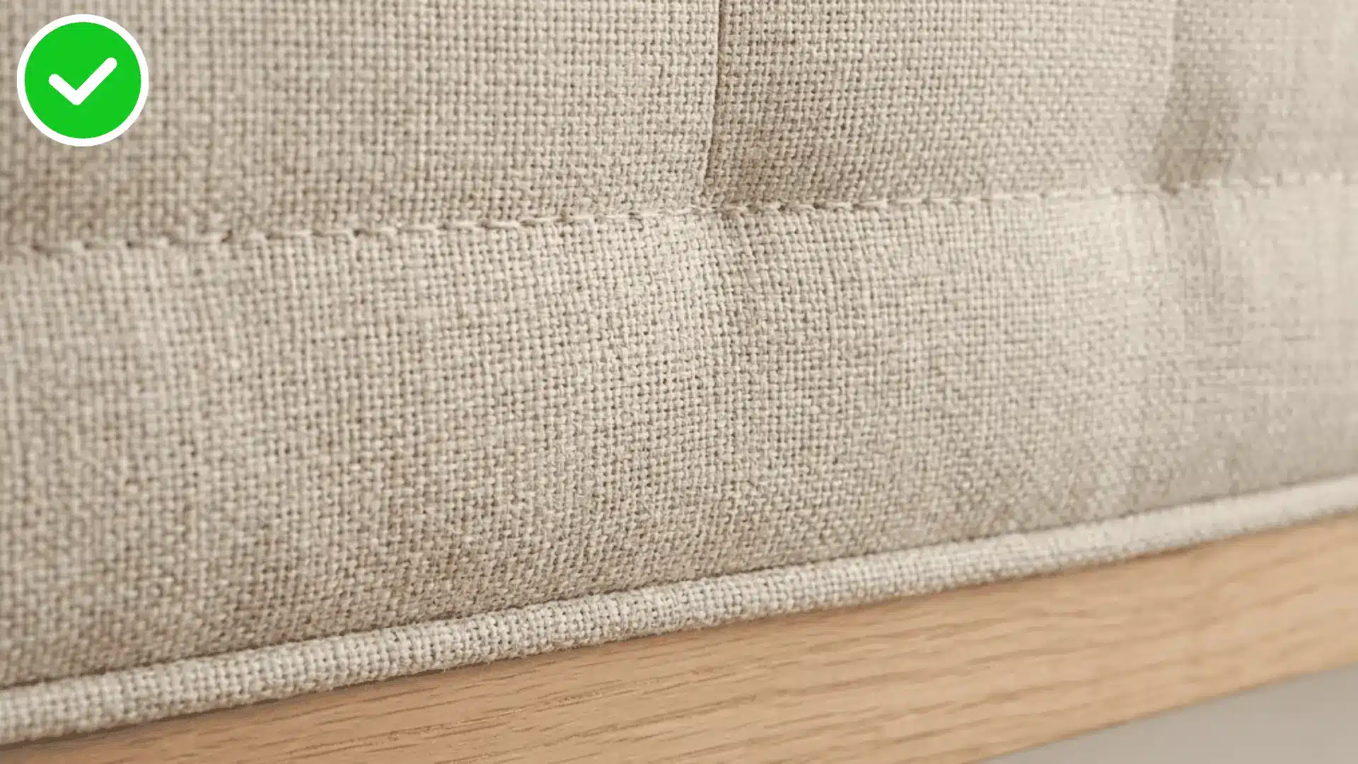 macro shot of upholstered headboard fabric weave and a single stitched seam