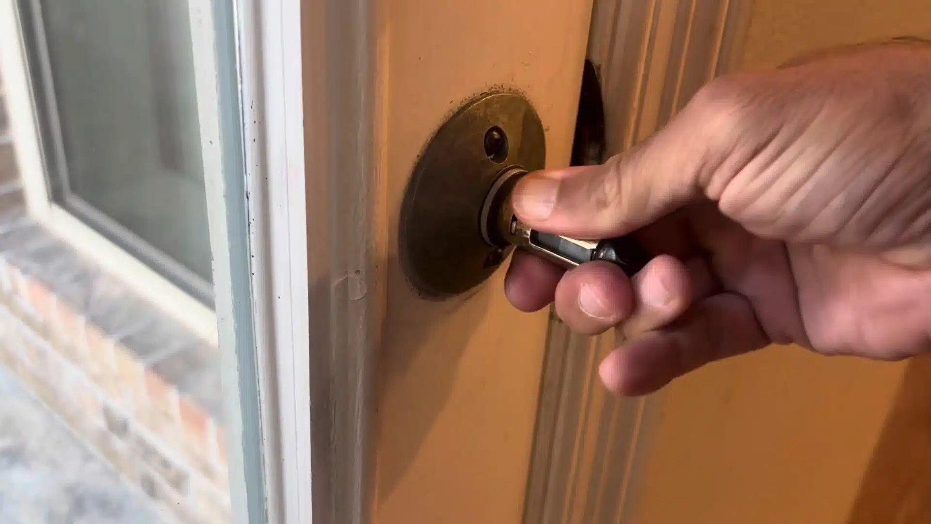 man pulling the spindle mechanism away from the round mounting plate on the door