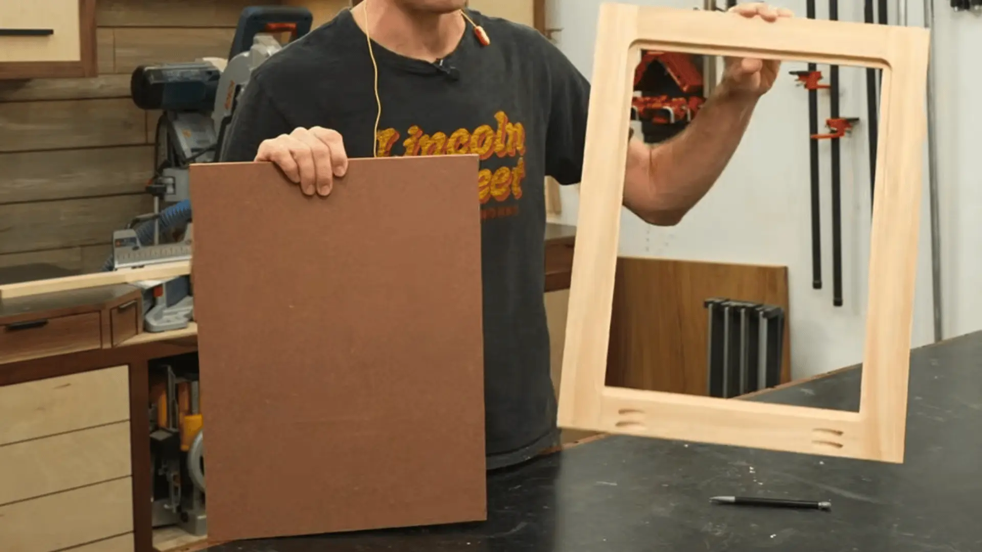 woodworker holding an MDF center panel next to a solid wood rail and stile door frame with a grooved edge