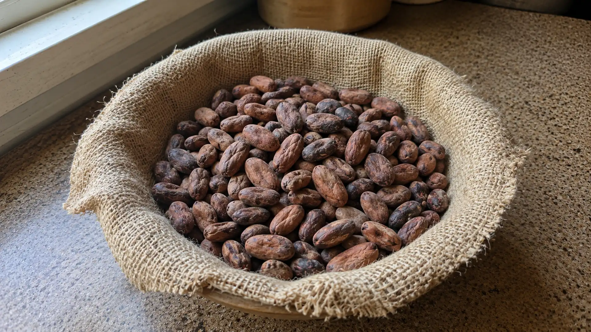 raw cocoa beans in a small bowl on a kitchen wooden counter