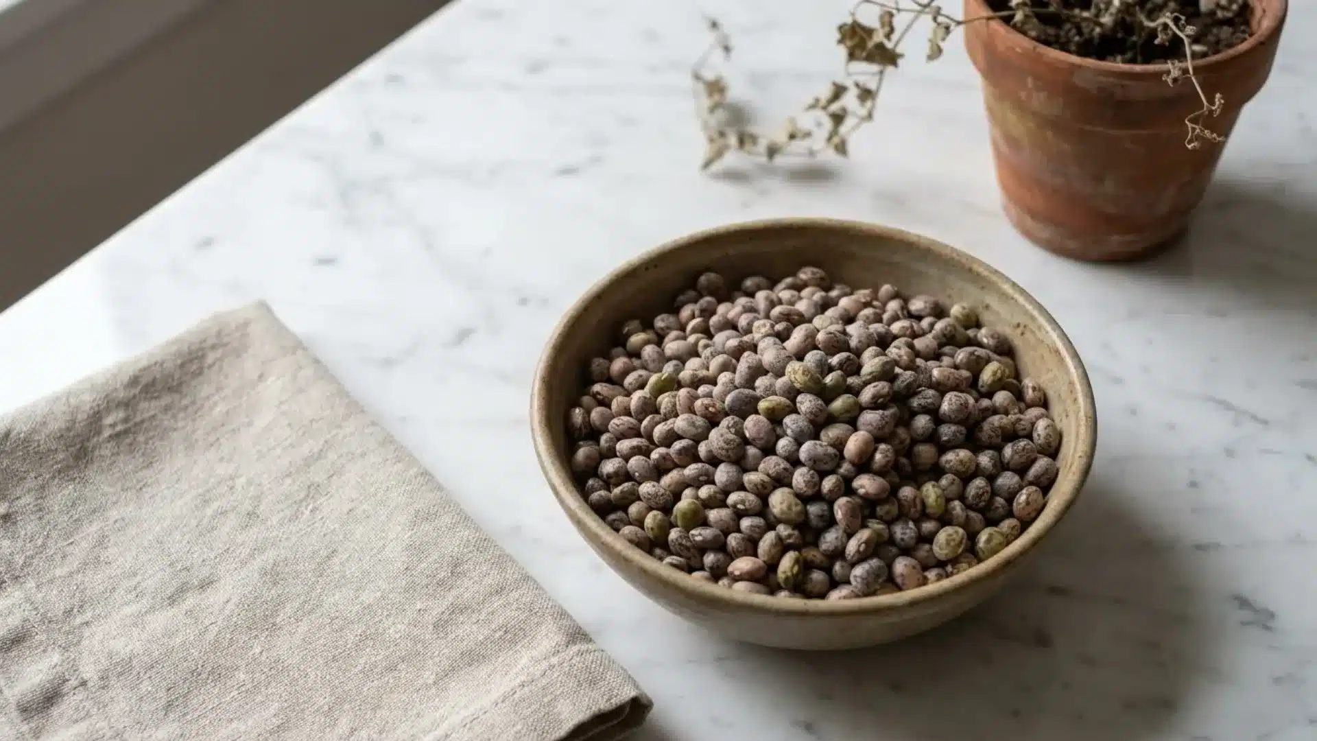 dried field peas in a ceramic bowl showing their small mottled brown and tan speckled seeds