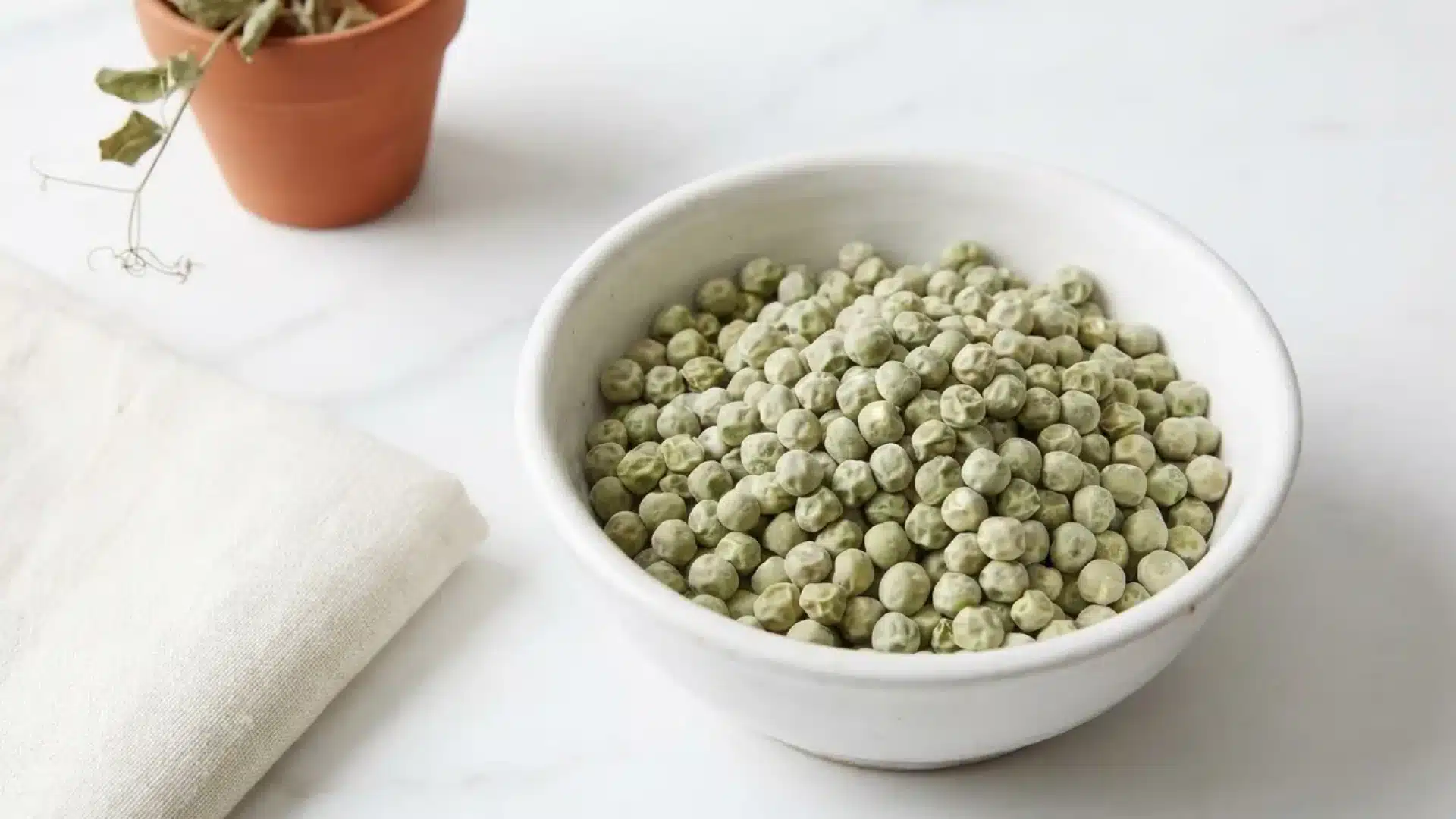 dried marrowfat peas in a bowl showing their pale green wrinkled dimpled skin texture
