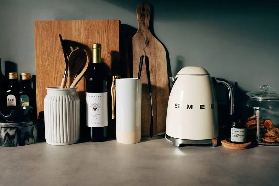 Kitchen countertop with white kettle, wooden cutting boards, wine bottle, and cooking utensils in jars